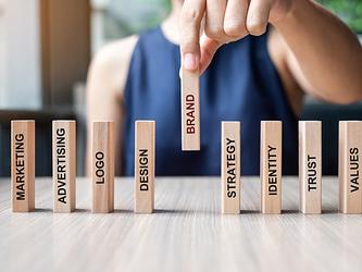 Wooden blocks with one that has the word 'brand' written on it
